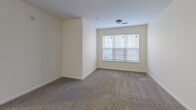 This 1070 square foot apartment in Greensboro, NC offers a well-designed living space with three bedrooms and two bathrooms. The single-story layout maximizes functionality, with the primary bedroom boasting a generous 240 square feet. The heart of the home is an open-concept area combining the living room, dining room, and kitchen. The kitchen features wooden cabinetry, granite countertops, and black appliances, creating a modern yet warm atmosphere. Throughout the apartment, neutral-toned carpeting in the bedrooms and living areas contrasts with tiled flooring in the kitchen and bathrooms. The bathrooms are equipped with essential fixtures, including a bathtub-shower combination. Large windows in the bedrooms and living area allow for ample natural light, while ceiling-mounted light fixtures provide additional illumination. Storage is a key feature, with multiple closets featuring wire shelving systems. The overall design emphasizes clean lines and a bright, airy feel, creating a comfortable and inviting living environment.