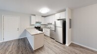 Located at 200 Berryhill Rd in Columbia, SC, this two-bedroom, one-bathroom unit offers a well-designed single-floor layout that makes efficient use of its space. The kitchen is a standout feature, showcasing white shaker-style cabinetry, granite-look countertops, a peninsula breakfast bar, and a full suite of stainless steel appliances including a refrigerator, dishwasher, and electric range. Wood-style plank flooring runs throughout the main living and kitchen areas, adding warmth and visual continuity. Both bedrooms are carpeted for comfort and each is equipped with a ceiling fan and natural light from windows overlooking surrounding greenery. The primary bedroom offers a generous footprint, providing ample room for furnishings. A dedicated closet adds practical storage to the layout. The bathroom is cleanly finished in white, featuring a single-sink vanity with white cabinetry, a framed mirror, and a full tub-shower combination. Neutral gray tones on the walls throughout the unit create a calm, cohesive aesthetic. The overall design is modern, clean, and move-in ready, offering comfortable residential living in Columbia, South Carolina.