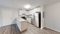 Located at 200 Berryhill Rd in Columbia, SC, this two-bedroom, one-bathroom unit offers a well-designed single-floor layout that makes efficient use of its space. The kitchen is a standout feature, showcasing white shaker-style cabinetry, granite-look countertops, a peninsula breakfast bar, and a full suite of stainless steel appliances including a refrigerator, dishwasher, and electric range. Wood-style plank flooring runs throughout the main living and kitchen areas, adding warmth and visual continuity. Both bedrooms are carpeted for comfort and each is equipped with a ceiling fan and natural light from windows overlooking surrounding greenery. The primary bedroom offers a generous footprint, providing ample room for furnishings. A dedicated closet adds practical storage to the layout. The bathroom is cleanly finished in white, featuring a single-sink vanity with white cabinetry, a framed mirror, and a full tub-shower combination. Neutral gray tones on the walls throughout the unit create a calm, cohesive aesthetic. The overall design is modern, clean, and move-in ready, offering comfortable residential living in Columbia, South Carolina.