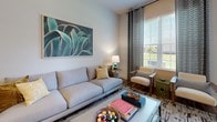 This single-floor residence in Fredericksburg, Virginia, offers a thoughtfully designed layout with contemporary finishes and a cohesive aesthetic carried throughout every room. The open-concept floor plan connects the kitchen, dining, and living areas, creating a seamless flow ideal for both daily living and entertaining.

The kitchen is a standout feature, showcasing rich dark-espresso cabinetry extending to the ceiling, a mosaic tile backsplash, stainless steel appliances, and a peninsula with a white quartz countertop and undermount sink. Warm hardwood-style flooring runs through the main living areas, complementing the neutral wall tones and modern pendant lighting.

The living room is bright and welcoming, with large windows dressed in patterned drapes that invite natural light and offer outdoor views. The bedroom features soft carpeting, generous window coverage, and a walk-in closet, creating a calm and restful retreat. The bathroom continues the design language with dark cabinetry, a white countertop vanity, and hardwood-style flooring.

Throughout the residence, neutral walls and carefully chosen finishes create a refined, move-in-ready environment with a clean, modern sensibility.
