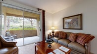 Located at 1100 Dennery Rd in San Diego, CA, this single-story residence offers a thoughtfully laid-out floor plan with comfortable living spaces throughout. The living room serves as the heart of the home, featuring soft carpeting, gently vaulted ceilings, and a large sliding glass door that opens to a private patio with views of lush greenery — filling the space with natural light. An arched doorway adds architectural character and connects the living area to the rest of the home. Adjacent to the living room is a dedicated dining area with carpeted flooring, framed wall art, and convenient access to the front entry. The kitchen is finished with tile flooring, white cabinetry, dark granite-style countertops, and full appliances including a gas range and refrigerator, with double doors leading directly into an in-unit laundry room equipped with a washer and dryer. The bedrooms are carpeted and generously sized, each featuring large windows that invite natural light and garden views. A walk-in closet provides ample storage in one of the bedrooms. The bathroom includes a full soaking tub with shower, white tile surround, and tile flooring. This residence combines classic design details with functional living spaces in a serene San Diego setting.