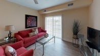This single-floor residence offers a thoughtfully designed layout with a cohesive warm color palette of soft yellows and neutral tones carried throughout. The living room provides a comfortable gathering space with hardwood-style flooring, while the adjacent dining area accommodates a full-sized table and chairs beneath a flush ceiling light, making it well-suited for entertaining.

The kitchen features rich, dark cabinetry paired with granite countertops and hardwood-style flooring, offering ample storage and workspace. A dedicated laundry room includes full-sized washer and dryer units alongside upper dark-wood cabinetry and tile flooring for added practicality.

The primary bedroom is generously sized with plush carpeting, a ceiling fan, and a large window providing natural light. It connects to a spacious walk-in closet lined with wire shelving systems offering versatile storage. A second bedroom, also carpeted with a large window, shares access to a full bathroom featuring tile flooring and a walk-in shower with a glass door. An additional bathroom with a shower-tub combination and tile flooring serves the remaining living areas.