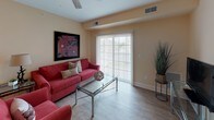 This single-floor residence offers a thoughtfully designed layout with a cohesive warm color palette of soft yellows and neutral tones carried throughout. The living room provides a comfortable gathering space with hardwood-style flooring, while the adjacent dining area accommodates a full-sized table and chairs beneath a flush ceiling light, making it well-suited for entertaining.

The kitchen features rich, dark cabinetry paired with granite countertops and hardwood-style flooring, offering ample storage and workspace. A dedicated laundry room includes full-sized washer and dryer units alongside upper dark-wood cabinetry and tile flooring for added practicality.

The primary bedroom is generously sized with plush carpeting, a ceiling fan, and a large window providing natural light. It connects to a spacious walk-in closet lined with wire shelving systems offering versatile storage. A second bedroom, also carpeted with a large window, shares access to a full bathroom featuring tile flooring and a walk-in shower with a glass door. An additional bathroom with a shower-tub combination and tile flooring serves the remaining living areas.
