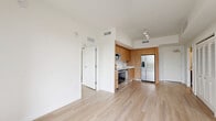Located at 15955 NW 6th Avenue in Miami, FL, this well-designed two-bedroom, two-bathroom residence offers a thoughtfully organized single-level layout. Light wood flooring flows consistently throughout every room, creating a cohesive and airy aesthetic complemented by crisp white walls and clean lines.

The open-concept living and kitchen area forms the heart of the home. The kitchen is outfitted with warm wood cabinetry extending to the ceiling, white countertops, a tile backsplash, and a full suite of stainless steel appliances including a range, microwave, dishwasher, and French door refrigerator. Track lighting overhead provides focused illumination for the space.

Both bedrooms are bright and functional, featuring windows dressed with horizontal blinds that allow natural light while maintaining privacy. One bedroom includes a sliding barn-style door, adding a modern design touch, while another features louvered closet doors for built-in storage. The primary bedroom offers access to a dedicated closet with open shelving.

Each bathroom is finished with a wood-toned floating vanity, white countertop, and a full tub-shower combo with white subway tile surrounds. The overall design is modern and minimalist, offering a clean, move-in-ready environment suited for comfortable urban living in Miami.