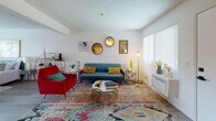 Located at 2301 E Market St in Long Beach, California, this single-floor unit offers a well-designed layout with a cohesive mid-century modern aesthetic throughout. The living area sets an inviting tone with bright white walls, light wood-style flooring, large windows that bring in natural light, and eclectic decor including round decorative mirrors, a tufted blue sofa, and a vibrant patterned area rug. The kitchen is thoughtfully updated with two-tone grey shaker cabinets, white quartz-style countertops, a stainless steel gas range, over-the-range microwave, dishwasher, and a retro black refrigerator — all complemented by track lighting and a clean tile backsplash. The bedroom is a calm retreat, featuring wood-style flooring, a textured ceiling, ample natural light from a sliding glass door with vertical blinds, and direct access to a stacked in-unit washer and dryer — a rare and convenient feature. The bathroom showcases a standout geometric patterned tile floor, a clean white tub-shower combination, and a small window for ventilation and light. Throughout the unit, the design balances functionality with personality, making it an informative and visually engaging space to explore.