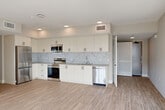 Located at 201 North La Brea Avenue in Inglewood, CA, this well-appointed 3-bedroom, 2-bathroom single-floor residence offers a clean, modern aesthetic throughout. Light wood-style flooring runs continuously across the open-concept layout, complementing the neutral warm-toned walls and crisp white trim.

The kitchen is a standout feature, showcasing floor-to-ceiling white cabinetry, a striking marble-patterned tile backsplash, and a full suite of stainless steel appliances including a refrigerator, electric range, over-the-range microwave, and dishwasher. Recessed lighting and a neutral countertop complete the polished look.

The living area is bright and airy, benefiting from large sliding glass doors and oversized windows that draw in generous natural light and offer views of the surrounding neighborhood. The spacious primary bedroom continues this bright character with large windows and a dedicated closet. The additional bedrooms are well-sized and include closet storage.

Both bathrooms are finished in a clean, contemporary style with wood-look flooring, vanities with neutral countertops, and accessible grab bars in at least one bathroom. A dedicated laundry area houses a stacked Samsung washer and dryer unit, adding everyday convenience to this thoughtfully designed residence.