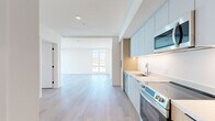 Located on Santa Monica Boulevard in the heart of West Los Angeles, this thoughtfully designed 2-bedroom, 2-bathroom residence combines modern aesthetics with functional living. Light hardwood flooring runs throughout, complementing a clean, white-and-neutral palette that enhances the sense of openness across every room.

The open-concept living area is bathed in natural light through expansive floor-to-ceiling windows, offering sweeping views of the surrounding Los Angeles cityscape. The kitchen is outfitted with sleek, soft-blue upper cabinetry paired with warm wood-toned lower cabinets, white quartz countertops, under-cabinet lighting, and a full suite of stainless steel appliances including a range, microwave, dishwasher, and refrigerator.

Both bedrooms are well-proportioned and bright, with the primary bedroom featuring large windows that frame outdoor views. Each bedroom is served by a dedicated bathroom, and generous walk-in closets provide ample storage. An in-unit stacked washer and dryer adds everyday convenience.

Throughout the residence, crisp white walls, recessed lighting, and minimalist door hardware lend a cohesive, contemporary character, making this a refined and move-in-ready home in one of LA's most accessible neighborhoods.