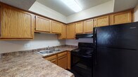 Located at 4334 Appian Way W in Gahanna, Ohio, this two-floor residence offers a practical and comfortable layout across its multiple living areas. The kitchen is well-appointed with warm oak cabinetry, dark granite-style countertops, a double-basin sink, and black appliances including a range with overhead ventilation and a full-size refrigerator. A mix of hardwood-style, tile, and plush carpeted flooring is found throughout the home, providing distinct character to each space. Living and bedroom areas feature neutral beige walls, textured ceilings, and vertical blinds over windows that allow natural light to filter in. One bedroom includes a ceiling fan and direct access to a bathroom, while another features dual mirrored sliding-door closets, offering generous storage. A lower-level bedroom provides a quieter retreat with a high horizontal window. The full bathroom is equipped with a tub-shower combination, a lighted vanity mirror, and a wood-framed sink cabinet with tile flooring. A separate half-bath with a window adds additional convenience. The overall layout is functional and well-organized, making this a practical home in the Gahanna community.