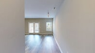 Located at 700 Darley Green Dr in Claymont, Delaware, this well-appointed one-bedroom, one-bathroom residence offers a thoughtfully designed single-floor layout. The open-concept kitchen and living area serves as the heart of the home, featuring rich dark wood cabinetry, granite countertops, a stainless steel refrigerator, gas range, and built-in microwave. Track lighting illuminates both the kitchen and living area, which is finished with warm hardwood-style flooring that extends throughout the main living spaces. The living area is generously proportioned, offering a clean, neutral palette with crisp white walls and ample room for a variety of furniture arrangements. The bedroom is a comfortable, carpeted retreat with a large window that invites natural light and provides outdoor views of the surrounding community. A dedicated walk-in closet with wire shelving offers practical storage. The bathroom is finished with light tile flooring, a dark wood vanity with a white countertop, a framed mirror, and chrome fixtures. A hallway connects the main living spaces, creating a logical and efficient flow throughout the residence. The overall ambiance is modern, clean, and move-in ready.