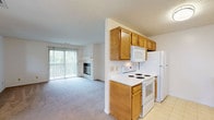 Located at 3070 Mill Pound Drive in Bellbrook, Ohio, this single-floor unit offers a well-organized layout designed for comfortable everyday living. The living room serves as the centerpiece of the space, featuring a tiled fireplace with a classic white mantel and a large sliding glass door fitted with vertical blinds that open to an outdoor balcony, allowing abundant natural light to fill the room. Soft carpet underfoot adds warmth to the living area.

The kitchen is designed in a galley style, offering ample storage through warm honey-toned wood cabinetry lining both walls, complemented by white countertops and light tile flooring. It includes a full suite of white appliances — a refrigerator, electric range, and over-the-range microwave — along with a double sink for added convenience.

The bedrooms are carpeted and bright, each featuring windows that offer views of the surrounding greenery, providing a calm and peaceful atmosphere. The bathroom is clean and functional, with light tile flooring, a vanity countertop, and simple, neutral finishes throughout.

A dedicated utility and laundry room provides practical storage space and houses the furnace unit, with washer and dryer hookups included. A ceiling fan in one of the secondary rooms adds to the overall comfort of this well-appointed single-level home.
