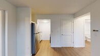 Located at 535 Orange Ave NE in Roanoke, Virginia, this single-floor, 2-bedroom, 2-bathroom residence offers a thoughtfully arranged layout that maximizes its compact footprint. The living room serves as the entry point, featuring rich, dark wood-style flooring that extends through the main living areas, creating a cohesive and polished look. A window near the front door allows natural light to brighten the space.

The galley-style kitchen is efficiently designed with white shaker cabinetry, light granite-style countertops, a stainless steel sink, and stainless steel appliances including a refrigerator, range, microwave, and dishwasher. Light wood-style flooring completes the kitchen's clean aesthetic.

Both bedrooms feature plush neutral carpeting and windows that bring in natural light. Each room offers a calm, functional atmosphere suitable for comfortable living. A walk-in closet with wire shelving provides generous storage, complemented by a second closet elsewhere in the unit.

The two bathrooms continue the wood-style flooring theme, with white cabinetry, mirrored vanities, and clean, modern finishes. A hallway connects the rooms, contributing to an efficient flow throughout the residence.