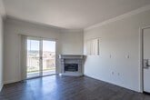 Located at 40800 Sunflower Rd in Murrieta, California, this single-story residence offers a well-designed layout with consistent light wood-tone flooring and crown molding throughout, creating a cohesive and polished aesthetic.

The living area is a standout space, featuring a classic stone fireplace and sliding glass doors that open to a wrought iron-railed balcony with sweeping views of the surrounding hills and landscape. Natural light fills the room, enhancing the airy, open feel. A second room also offers direct balcony access through sliding glass doors, further connecting the interior to the scenic outdoor setting.

The kitchen is thoughtfully laid out with warm honey-toned wood cabinetry lining both sides of the space, white appliances including a gas range, microwave, refrigerator, and dishwasher, and a tile backsplash. An adjoining dining or flex area with a ceiling fan sits open to the kitchen, offering versatility in how the space can be used.

The bathroom is finished with a wide granite-topped vanity, white cabinetry, a large mirror, and wood-look flooring, providing a clean and functional design. Throughout the home, neutral warm-white walls and abundant natural light contribute to a bright, welcoming atmosphere well-suited to the sunny Southern California setting.