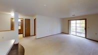 This single-floor unit offers a practical and well-organized layout across two bedrooms and one bathroom. The spacious living area is finished with light neutral carpet and features a sliding glass patio door that invites natural light and provides access to the outdoors. Warm wood-toned door frames and baseboards add a consistent design element throughout the unit.

The kitchen is efficiently arranged with medium-toned wood cabinetry, white laminate countertops, and includes appliances such as a refrigerator, dishwasher, and range. A peninsula-style breakfast bar separates the kitchen from the adjacent dining area, which features hard surface flooring and a pendant light fixture overhead.

Both bedrooms are carpeted and feature large windows with vertical blinds, allowing for ample natural light and outdoor views. The textured ceilings are consistent throughout the unit, contributing to a cohesive aesthetic.

The bathroom is cleanly finished with tile flooring, a tub-shower combination, and a vanity with storage. A full-length towel bar and ventilation are also present. The overall ambiance of the unit is neutral, functional, and move-in ready, suited for comfortable everyday living.