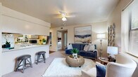 Located at 2601 W 12th St in Russellville, Arkansas, this single-floor, three-bedroom unit offers a well-organized and functional layout. The open-concept living and dining area connects seamlessly to the kitchen, creating a sociable and practical common space. The living room features plush carpeting, a ceiling fan with light fixture, a textured ceiling, and windows that admit generous natural light with views of the surrounding exterior. Neutral warm tones across the walls lend the space a cohesive, welcoming ambiance throughout.

The galley-style kitchen is efficiently designed with white cabinetry, white appliances including a range, refrigerator, and dishwasher, a double sink, and dark hardwood-style flooring. A breakfast bar with bar seating connects the kitchen to the living area, enhancing the open feel.

The primary bedroom offers carpeted flooring, a window for natural light, and closet storage. The two additional bedrooms are similarly appointed with carpet, windows, closet space, and neutral walls, providing comfortable and versatile accommodations. Each bedroom benefits from a quiet, private atmosphere.

A hallway connects the bedrooms to the main living areas, with closets providing additional storage throughout the unit. The overall design is practical and accessible, suited for a variety of living arrangements.