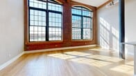 This 1090 square foot loft apartment seamlessly blends industrial character with modern comfort. The open floor plan showcases soaring ceilings, exposed brick walls, and expansive windows that flood the space with natural light, offering picturesque views. Gleaming hardwood floors run throughout, adding warmth to the contemporary aesthetic.

The kitchen is a highlight, boasting sleek stainless steel appliances, ample wooden cabinetry, and a convenient breakfast bar. Adjacent, the living and dining areas provide versatile space for relaxation and entertainment. The primary bedroom, measuring 180 square feet, offers a generous retreat, while a second bedroom provides additional flexibility.

Practical amenities include an in-unit laundry room with stacked washer and dryer, ensuring convenience. The bathroom, though not extensively detailed, likely continues the apartment's modern design. Unique architectural elements, such as exposed beams and columns, add to the loft's distinctive appeal.

Located at 300 Canal St in Lawrence, MA, this apartment combines the allure of converted industrial space with the comforts of contemporary living, making it an ideal urban dwelling for those seeking character and functionality.