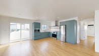 Located in Hollywood, this thoughtfully designed 2-bedroom, 2-bathroom residence offers a clean, modern aesthetic throughout. Warm light wood flooring flows seamlessly across the entire unit, creating a cohesive and inviting atmosphere in every room.

The open-concept kitchen and living area serves as the heart of the home. The kitchen is outfitted with flat-front cabinetry in a distinctive slate-blue finish, stainless steel appliances including a gas range, built-in microwave, and a full-size refrigerator, complemented by a white tile backsplash and warm wood open shelving. The living area is bright and airy, with sliding glass doors leading to a private balcony with neighborhood views.

The primary bedroom is generously sized, offering a wide window with city views and ample natural light. The second bedroom features mirrored sliding closet doors, adding depth and brightness. Both rooms are serviced by well-appointed bathrooms — one featuring a floating white vanity with an oval mirror, designer sconce lighting, and a glass-enclosed shower, while the second offers a full soaking tub with floor-to-ceiling white tile. Additional conveniences include dedicated closet space throughout and an in-unit laundry area.
