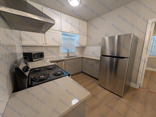 Cocina con electrodomésticos de acero inoxidable y encimeras de cuarzo. - 2608 19th Ave W