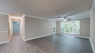 Located at 9200 Roberts Dr. in Sandy Springs, GA, this single-story residence offers a well-designed layout with a cohesive, neutral color palette throughout. The open living and dining area is highlighted by rich wood-look flooring, crown molding, and a ceiling fan with light fixture. A chandelier illuminates the dining space, which connects seamlessly to the living area through an open-concept flow. A built-in shelving unit adds functional character to the living room, while a private exterior door and large windows invite abundant natural light and views of surrounding greenery.

The galley-style kitchen is equipped with dark espresso cabinetry, light stone-look countertops, a tile backsplash, and stainless steel appliances including a range and dishwasher. A pass-through counter opening connects the kitchen to the main living area. Bedrooms feature plush carpeting, ceiling fans, and windows overlooking the wooded surroundings. The bathroom includes a full soaking tub with white tile surround, adding a clean, classic finish. Throughout the space, consistent trim work, textured ceilings, and warm tones create a comfortable and well-maintained living environment.