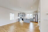 Located at 216 Meyers Ridge Rd in Cramerton, NC, this two-story home offers a well-designed layout across two balanced floors. The main level features a bright, open-concept living, dining, and kitchen area with warm light wood-look flooring throughout. The kitchen is a standout, equipped with gray shaker-style cabinetry, white countertops, a center island, stainless steel appliances including a refrigerator with ice dispenser, and multiple windows that fill the space with natural light. A dedicated entrance, laundry area, and two outdoor patio spaces complete the first floor. Upstairs, three bedrooms are finished with plush carpet flooring, each offering generous closet space — including walk-in closets with wire shelving systems. The primary bedroom features its own en-suite bathroom with a sliding glass shower enclosure, gray vanity cabinetry, and stone-look tile flooring. Two additional bathrooms serve the remaining bedrooms, each finished with matching tile flooring, white vanities, and tub-shower combinations. Six total closets throughout the home ensure ample storage. Clean white walls, recessed lighting, and a consistent design palette give the entire home a bright, modern, and move-in-ready feel.