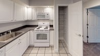 Located at Presidio Pointe Place in Cross Lanes, West Virginia, this single-floor residence offers a well-organized and practical layout designed for comfortable everyday living. The open living area flows naturally into the kitchen, which features white cabinetry, dark granite-style countertops, white appliances including a range, microwave, and refrigerator, and clean tile flooring. A dedicated pantry with wire shelving provides ample dry storage directly off the kitchen.

The bedrooms are carpeted and generously sized, each equipped with ceiling fans for year-round comfort. Natural light enters through double windows with blinds, creating a bright and pleasant atmosphere. One bedroom includes a spacious walk-in closet outfitted with wire shelving and a hanging rod, offering excellent organizational capacity.

The bathroom is cleanly finished with white tile flooring, a vanity featuring a granite-style countertop and stainless steel sink, white cabinetry below, and a full shower-tub combination with built-in shelving. The crisp white color palette throughout the bathroom contributes to a clean, functional aesthetic.

Neutral tones, white trim, and consistent finishes across the space create a cohesive and move-in-ready environment suited for a range of lifestyles.