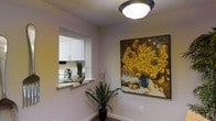 Located at 600 S Churton St in Hillsborough, NC, this two-story residence offers a thoughtfully arranged layout designed for comfortable everyday living. The interior features neutral-toned walls throughout, creating a clean and versatile backdrop that adapts well to a variety of décor styles. A textured ceiling adds subtle character to the living areas, complemented by flush-mount lighting fixtures that provide consistent, even illumination.

A standout architectural detail is the pass-through window connecting the kitchen to the adjacent living or dining area — a practical and classic design element that promotes an open feel between spaces while maintaining a defined kitchen zone. The kitchen itself is outfitted with white cabinetry featuring brushed nickel hardware, offering ample storage and a bright, tidy aesthetic.

The living areas carry a warm ambiance, enhanced by soft carpeting underfoot and decorative touches such as potted greenery and wall art that lend the space a homey character. The two-story configuration provides a natural separation between living and private spaces, adding both functionality and a sense of spaciousness to the overall floor plan. This Hillsborough property combines practical design features with a welcoming atmosphere suitable for a range of lifestyles.