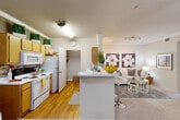 Located at 555 Spring Park Center Blvd in Spring, TX, this one-bedroom, one-bathroom residence offers a thoughtfully organized single-floor layout totaling 660 square feet. The open-concept living and kitchen area forms the heart of the home, where warm hardwood-style flooring transitions seamlessly between spaces. The kitchen features light wood cabinetry, a white appliance suite including a range and over-the-range microwave, and a peninsula counter that doubles as a breakfast bar. Crown molding accents the kitchen and dining nook, which includes built-in shelving for added storage and display.

The living room is carpeted and filled with natural warmth, highlighted by a ceiling fan with light fixture, track lighting, and wall-mounted shelving for media and décor. The bedroom is generously sized, featuring plush carpet, a ceiling fan, a built-in desk nook, and windows that allow ample natural light. The full bathroom offers a tub-shower combination with a window above, wood-style flooring, and direct access to a walk-in closet. A dedicated laundry room with hardwood-style flooring and shelving adds everyday convenience to this well-appointed home.