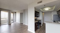 This single-floor residential unit at 1602 Jackson Keller Rd in San Antonio, Texas, offers a thoughtfully designed layout with a neutral color palette and modern finishes throughout. The kitchen is a standout feature, equipped with dark espresso cabinetry, granite-style countertops, stainless steel appliances including a refrigerator, dishwasher, microwave, and gas range, along with a peninsula that opens toward the living and dining areas. Wood-style plank flooring flows throughout the main living spaces and kitchen, adding warmth and continuity.

The living and dining areas are generously proportioned, with natural light filtering through horizontal and vertical blinds, and a pendant light fixture accentuating the dining space. A sliding glass door provides access to an outdoor area. The bedrooms feature plush carpeting, ceiling fans, and windows that bring in additional natural light.

Two bathrooms serve the unit — one features decorative diagonal tile work in the shower/tub surround, tile flooring, and a dark-cabinetry vanity with granite-style countertops. The second bathroom includes a tiled tub/shower combination, a large wall mirror, and matching cabinetry. A central hallway connects the private areas of the unit efficiently. The textured ceilings are consistent throughout, lending a classic residential character to the space.