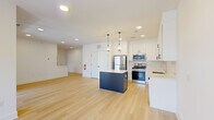 Located at 50 Kirby Ave in Somerville, NJ, this two-floor residence offers a thoughtfully designed layout with 1 bedroom and 1 bathroom spread across a generous floor plan. Light hardwood floors and a neutral color palette run throughout, creating a bright and cohesive aesthetic.

The main level centers around an open-concept kitchen and living area. The kitchen is well-appointed with white shaker cabinetry, a classic subway tile backsplash, quartz countertops, stainless steel appliances including a gas range, microwave, refrigerator, and dishwasher, and a navy blue center island topped with pendant lighting. Recessed lighting brightens the entire space.

A carpeted staircase with clean white railings connects the two floors. The spacious primary bedroom features light hardwood flooring, a ceiling fan, large windows offering neighborhood views, and sliding glass doors leading to a private balcony. An additional room with a bright window provides flexible use as an office or secondary living space.

The bathroom is finished with a clean, all-white tub and shower combination with chrome fixtures. Throughout the residence, the design emphasizes clean lines, contemporary finishes, and an abundance of natural light, making for a comfortable and modern living environment.