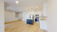 Located at 50 Kirby Ave in Somerville, NJ, this two-floor residence offers a thoughtfully designed layout with 1 bedroom and 1 bathroom spread across a generous floor plan. Light hardwood floors and a neutral color palette run throughout, creating a bright and cohesive aesthetic.

The main level centers around an open-concept kitchen and living area. The kitchen is well-appointed with white shaker cabinetry, a classic subway tile backsplash, quartz countertops, stainless steel appliances including a gas range, microwave, refrigerator, and dishwasher, and a navy blue center island topped with pendant lighting. Recessed lighting brightens the entire space.

A carpeted staircase with clean white railings connects the two floors. The spacious primary bedroom features light hardwood flooring, a ceiling fan, large windows offering neighborhood views, and sliding glass doors leading to a private balcony. An additional room with a bright window provides flexible use as an office or secondary living space.

The bathroom is finished with a clean, all-white tub and shower combination with chrome fixtures. Throughout the residence, the design emphasizes clean lines, contemporary finishes, and an abundance of natural light, making for a comfortable and modern living environment.