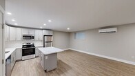 Located at 204 E Chester Pike in Ridley Park, PA, this thoughtfully designed one-bedroom, two-bathroom unit offers a clean, modern aesthetic with quality finishes throughout. The open-concept kitchen and living area serves as the heart of the space, featuring soft gray shaker-style cabinetry, a white quartz waterfall island, stainless steel appliances including a refrigerator, range, microwave, and dishwasher, and a white subway tile backsplash. Warm-toned luxury vinyl plank flooring runs throughout, complementing the neutral gray walls and crisp white trim. Recessed lighting illuminates the kitchen and living area, while a wall-mounted mini-split system ensures year-round climate comfort. The spacious primary bedroom includes a dedicated closet, a wall-mounted mini-split unit, and a window with blinds that brings in natural light. Two well-appointed bathrooms complete the unit — one featuring a backlit vanity mirror, single-sink vanity, and a glass-enclosed marble-tiled shower, and the other offering a similar refined design. Clean lines, a neutral color palette, and modern hardware unify the space, creating a cohesive and contemporary living environment.