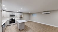Located at 204 E Chester Pike in Ridley Park, PA, this thoughtfully designed one-bedroom, two-bathroom unit offers a clean, modern aesthetic with quality finishes throughout. The open-concept kitchen and living area serves as the heart of the space, featuring soft gray shaker-style cabinetry, a white quartz waterfall island, stainless steel appliances including a refrigerator, range, microwave, and dishwasher, and a white subway tile backsplash. Warm-toned luxury vinyl plank flooring runs throughout, complementing the neutral gray walls and crisp white trim. Recessed lighting illuminates the kitchen and living area, while a wall-mounted mini-split system ensures year-round climate comfort. The spacious primary bedroom includes a dedicated closet, a wall-mounted mini-split unit, and a window with blinds that brings in natural light. Two well-appointed bathrooms complete the unit — one featuring a backlit vanity mirror, single-sink vanity, and a glass-enclosed marble-tiled shower, and the other offering a similar refined design. Clean lines, a neutral color palette, and modern hardware unify the space, creating a cohesive and contemporary living environment.