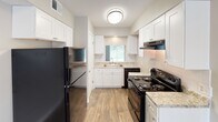 Located at 3160 Timberbrook Dr in Charlotte, NC, this two-floor home offers a well-organized layout with a mix of updated finishes and functional design throughout. The main level features a spacious living area finished with durable wood-look flooring and neutral gray walls, filling the space with a clean, modern aesthetic. A sliding glass door floods the room with natural light and provides direct views of and access to the outdoor greenery beyond.

The kitchen is thoughtfully renovated, showcasing white shaker-style cabinetry, granite-look countertops, and black appliances including a refrigerator, electric range, and dishwasher. Wood-look flooring continues through this space, complementing the bright, window-lit design. The bathroom features a tiled tub-shower combo, a white vanity with granite countertops, and wood-look flooring, maintaining a cohesive, updated look.

The upper floor hosts multiple carpeted bedrooms, each finished with soft neutral tones, textured ceilings, and windows that bring in natural light. One room on the lower level features wood-look flooring and panel-style doors, offering additional flexible living or sleeping space. Throughout both floors, the home presents a consistent, refreshed interior suited for comfortable everyday living.
