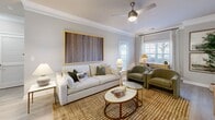 Located at 1411 Parkview Circle in Wilmington, NC, this thoughtfully designed one-bedroom, one-bathroom residence offers a efficient and comfortable single-floor layout. The open-concept kitchen and living area serves as the heart of the home, featuring white shaker cabinetry, white quartz countertops, a subway tile backsplash, stainless steel appliances including a dishwasher, gas range, and refrigerator, and a center island with bar seating and pendant lighting overhead. Light wood-tone flooring runs throughout the main living areas, complementing the neutral gray-green palette. The living room is bright and airy, with crown molding, a ceiling fan, and multiple windows that invite natural light. A glass door provides direct access to the private balcony. The bedroom offers carpeted flooring, a ceiling fan, and a natural light through windows with window treatments, along with access to two closets for ample storage. The bathroom features a white vanity with quartz countertop, a tub-shower combination with classic subway tile surround, and consistent wood-tone flooring. Additional conveniences include an in-unit laundry area and a utility room, rounding out this well-equipped Wilmington residence.