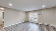 Located at 18 Brookside Ave in Worcester, MA, this single-floor unit has been thoughtfully updated with a cohesive, modern aesthetic throughout. The living area features light gray luxury vinyl plank flooring, recessed lighting, and a wall-mounted air conditioning unit. French doors allow natural light to fill the space and provide views of the surrounding neighborhood, while a baseboard heating system ensures year-round comfort.

The kitchen is well-appointed with white shaker-style cabinetry, white quartz countertops, a stainless steel sink with a brushed nickel faucet, and a gray subway tile backsplash that extends across the walls. Stainless steel appliances, including a dishwasher and refrigerator, complete the space. An adjacent entry area offers a closet and direct exterior access.

The bedrooms are carpeted in soft gray, each featuring baseboard heating and windows with blinds that provide natural light. The primary bedroom includes a closet with bi-fold doors. The bathroom is finished with gray subway tile surrounding the tub and shower, light wood-look flooring, a white vanity with brushed nickel hardware, and a framed mirror, presenting a clean and cohesive design.