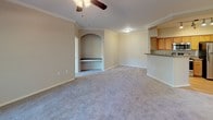 Located at 5225 Zachary Grove in Colorado Springs, Colorado, this single-floor residence offers a well-designed layout with a blend of comfortable living spaces and practical features throughout. The open-concept living room is a standout area, highlighted by crown molding, a ceiling fan, and a charming arched built-in nook with a bench — an architectural detail that adds character to the space. Plush carpeting runs throughout the living and bedroom areas, contributing to a warm and inviting atmosphere. The kitchen is thoughtfully designed with warm oak cabinetry, dark countertops, and a full suite of stainless steel appliances including a refrigerator, electric range, microwave, and dishwasher. Track lighting overhead and wood-look flooring complete the kitchen's functional and appealing aesthetic. A breakfast bar provides a natural transition between the kitchen and living area. The bedrooms are generously proportioned, each featuring carpet, large windows that invite natural light, and ceiling fixtures. One bedroom includes access to a walk-in closet with built-in shelving. The bathrooms are finished with wood-look flooring, white vanity cabinetry, and a tub-shower combination with tiled surround. An in-unit laundry area with a top-loading washer adds everyday convenience to this well-appointed Colorado Springs home.