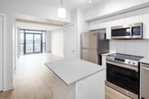 Located at 3385 Dundas St W in Toronto's vibrant west end, this well-appointed one-bedroom, one-bathroom unit offers a thoughtfully designed layout with clean, contemporary finishes throughout. Light-toned hardwood flooring flows seamlessly across the open-concept main living area, creating a bright and cohesive aesthetic.

The kitchen is a standout feature, outfitted with sleek white cabinetry extending to the ceiling, a subway tile backsplash, quartz countertops, and a full suite of stainless steel appliances including a refrigerator, range, built-in microwave, and dishwasher. A central island provides additional prep space and casual seating. The kitchen opens directly into the living area, which benefits from large floor-to-ceiling windows and sliding glass doors leading to a private balcony with open city views.

The bedroom is a comfortable, well-proportioned room featuring a window overlooking the surrounding neighbourhood and a dedicated closet for ample storage. The bathroom is finished with large-format floor tiles and includes a full tub-shower combination. A separate closet provides additional storage within the unit. The overall design is modern and neutral, making for a bright, functional, and move-in ready space.