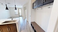Located at 5001 White Settlement Rd in Fort Worth, TX, this one-bedroom, one-bathroom residence offers a thoughtfully designed single-floor layout with modern finishes throughout. The open-concept kitchen and living area serves as the heart of the home, anchored by a striking center island topped with light granite countertops and an undermount sink. Dark espresso shaker cabinets provide bold contrast against the neutral walls, while stainless steel appliances and sleek pendant lighting add a contemporary touch. Track lighting above and light wood-tone flooring complete the polished aesthetic. The living area extends naturally from the kitchen and features access to a private outdoor balcony through a glass-panel door, flanked by windows that invite natural light and outdoor views. The bedroom is a comfortable, carpeted retreat with a ceiling fan and clean white walls. The full bathroom is well-appointed with a double-sink vanity topped with stone counters, a glass-enclosed walk-in shower, wood-look tile flooring, and a window that brings in natural light. A dedicated in-unit laundry room with full-size washer and dryer hookups adds everyday convenience to this refined and functional Fort Worth residence.