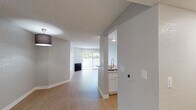 Located in the Koreatown neighborhood of Los Angeles, this single-floor unit at 130 S Alexandria Ave offers a clean, modern interior with a thoughtfully designed open layout. Light wood-style flooring runs throughout the space, complementing the neutral gray walls and white trim that give the unit a bright, cohesive feel.

The living area is generously proportioned, anchored by a fireplace and a sliding glass door that floods the room with natural light and provides access to an outdoor area. Adjacent to the living room, the kitchen features a peninsula counter that opens to the main living space, white shaker-style cabinetry, stainless steel appliances including a refrigerator and microwave, and a sleek modern faucet — making it both functional and visually appealing.

The bedrooms are well-sized with ample natural light from exterior-facing windows, and each connects conveniently to a bathroom. Two full bathrooms serve the unit, both finished with white cabinetry, light countertops, wood-style flooring, and shower-tub combinations. A hallway connects the private areas of the unit, maintaining a clear separation between the living and sleeping spaces.

Textured ceilings and recessed lighting add dimension throughout, while the overall design prioritizes clean lines and a move-in-ready aesthetic in the heart of Los Angeles.
