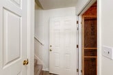 Located at 1400 Gallery Place Dr in Jackson, Michigan, this two-story, 2-bedroom, 2-bathroom home offers a functional and comfortable layout spread across two floors. The main living level hosts the majority of the space, including an open-concept kitchen and living room anchored by vaulted ceilings and a large window that fills the area with natural light. The kitchen features white cabinetry with wood-tone accents, light countertops, a double-basin sink, a dishwasher, and a pendant light over the pass-through that connects seamlessly to the living area. The living room is carpeted and benefits from the vaulted ceiling, creating an airy, open ambiance. Both bedrooms are carpeted and include ceiling fans and windows with views of outdoor greenery. The generously sized primary bedroom connects to a walk-in closet outfitted with wire shelving on multiple levels. The two bathrooms are clean and functional, each featuring light wood-tone flooring, a vanity with a wide mirror, and a shower enclosure. A dedicated laundry area includes washer/dryer hookups alongside an additional closet with wire shelving. The attached garage, accessed via a staircase entry, provides secure parking and storage. Textured ceilings, six-panel doors with brass hardware, and light-toned walls are consistent throughout.