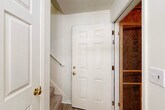 Located at 1400 Gallery Place Dr in Jackson, Michigan, this two-story, 2-bedroom, 2-bathroom home offers a functional and comfortable layout spread across two floors. The main living level hosts the majority of the space, including an open-concept kitchen and living room anchored by vaulted ceilings and a large window that fills the area with natural light. The kitchen features white cabinetry with wood-tone accents, light countertops, a double-basin sink, a dishwasher, and a pendant light over the pass-through that connects seamlessly to the living area. The living room is carpeted and benefits from the vaulted ceiling, creating an airy, open ambiance. Both bedrooms are carpeted and include ceiling fans and windows with views of outdoor greenery. The generously sized primary bedroom connects to a walk-in closet outfitted with wire shelving on multiple levels. The two bathrooms are clean and functional, each featuring light wood-tone flooring, a vanity with a wide mirror, and a shower enclosure. A dedicated laundry area includes washer/dryer hookups alongside an additional closet with wire shelving. The attached garage, accessed via a staircase entry, provides secure parking and storage. Textured ceilings, six-panel doors with brass hardware, and light-toned walls are consistent throughout.