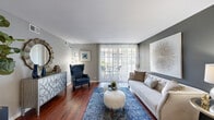 Located at 4773 Lake Valley Dr in Lisle, Illinois, this single-floor residence offers a cohesive and thoughtfully designed layout unified by rich, dark hardwood flooring that extends throughout the entire home. Neutral gray walls provide a versatile backdrop across all rooms, contributing to a calm and contemporary ambiance.

The living room serves as the centerpiece of the home, featuring a large sliding glass door dressed with vertical blinds that floods the space with natural light and provides direct access to an outdoor patio area. The room offers generous proportions suitable for comfortable seating arrangements.

Adjacent to the living room, a dedicated dining area accommodates a round table and seating for four, accented by a ceiling fan overhead. The space connects smoothly to the galley-style kitchen, which is well-equipped with stainless steel appliances, white shaker cabinetry, light granite countertops, a subway tile backsplash, and a stainless steel sink.

The bedroom receives natural light through multiple windows fitted with wood blinds, creating a bright yet private retreat. The bathroom features a full tub and shower combination with clean white tile surround and chrome fixtures, finished with gray walls that maintain the home's consistent design palette.