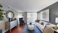 Located at 4773 Lake Valley Dr in Lisle, Illinois, this single-floor residence offers a cohesive and thoughtfully designed layout unified by rich, dark hardwood flooring that extends throughout the entire home. Neutral gray walls provide a versatile backdrop across all rooms, contributing to a calm and contemporary ambiance.

The living room serves as the centerpiece of the home, featuring a large sliding glass door dressed with vertical blinds that floods the space with natural light and provides direct access to an outdoor patio area. The room offers generous proportions suitable for comfortable seating arrangements.

Adjacent to the living room, a dedicated dining area accommodates a round table and seating for four, accented by a ceiling fan overhead. The space connects smoothly to the galley-style kitchen, which is well-equipped with stainless steel appliances, white shaker cabinetry, light granite countertops, a subway tile backsplash, and a stainless steel sink.

The bedroom receives natural light through multiple windows fitted with wood blinds, creating a bright yet private retreat. The bathroom features a full tub and shower combination with clean white tile surround and chrome fixtures, finished with gray walls that maintain the home's consistent design palette.