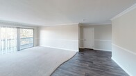 Located at 4351 Boardwalk Dr in Huntington Beach, California, this single-floor residence offers a well-appointed interior with consistent, quality finishes throughout. The living area serves as the focal point of the home, highlighted by a striking floor-to-ceiling stone fireplace and a large picture window that fills the space with natural light and frames views of lush greenery outside. Crown molding, chair rail detailing, and neutral tones lend a polished, cohesive aesthetic throughout.

The galley-style kitchen is efficiently designed with ample white cabinetry, granite countertops, light wood-look flooring, and a full suite of stainless steel appliances including a range, over-the-range microwave, refrigerator, and dishwasher. Recessed lighting provides bright, even illumination across the workspace.

The bedrooms are carpeted for comfort and feature crown molding, chair rail accents, sliding glass door access to an outdoor area, and walk-in closets with built-in shelving. The bathrooms echo the home's design language with granite-topped vanities, white cabinetry, wood-look flooring, crown molding, and chair rail details. A ceiling fan in the dining area adds both function and character. The overall ambiance is clean, bright, and move-in ready.