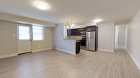 Located at 3241 Hulmeville Rd in Bensalem, PA, this single-floor residence offers a clean, modern layout designed for comfortable everyday living. The open-concept main area seamlessly connects the living space to the kitchen, creating a bright and functional environment. Light-toned laminate flooring runs throughout, lending the space a fresh and cohesive feel.

The kitchen is a standout feature, appointed with dark espresso cabinetry that provides a striking contrast against the light walls and flooring. Stainless steel appliances — including a refrigerator and gas range — deliver a contemporary, practical finish. A peninsula-style counter separates the kitchen from the living area, offering additional prep space and casual seating potential. Pendant lighting above the peninsula adds a stylish touch, while flush-mounted ceiling fixtures ensure consistent illumination throughout.

Natural light filters in through the windows, brightening the living area and enhancing the open atmosphere of the space. Neutral-toned walls complement the overall design, creating a versatile backdrop suited to a variety of décor styles. The thoughtful layout and modern finishes throughout make this a well-appointed and move-in ready space in the heart of Bensalem.