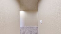 Located at 9823 NE 130th Pl in Kirkland, WA, this single-floor residence offers three bedrooms, two bathrooms, and a thoughtfully arranged layout. The combined living and dining area serves as the heart of the home, featuring plush carpeting, a textured ceiling, baseboard heating, and a fireplace flanked by recessed display niches. Multiple windows invite natural light and views of the surrounding greenery, while sliding glass doors open to a private balcony. The kitchen connects conveniently to the main living space, supporting easy everyday flow. The generously sized primary bedroom offers ample room for a full furniture arrangement, complemented by good natural light and closet access. The two additional bedrooms are carpeted and bright, each with windows overlooking the outdoors and baseboard heaters for year-round comfort. Five closets throughout the home provide excellent storage capacity. The two bathrooms are cleanly finished — one featuring a full tub/shower combo and wood-look flooring, the other with a separate water closet. A hallway connects the private areas of the home efficiently. The overall aesthetic is neutral and move-in ready, with a consistent warm tone throughout.
