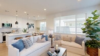 Located at 400 Stanford Crossing in Lathrop, CA, this modern two-story home offers 3 bedrooms and 5 bathrooms across two well-proportioned floors. The ground floor establishes a clean, contemporary aesthetic with light wood-look flooring and a bright, open-concept kitchen and dining area. The kitchen is a standout, featuring crisp white shaker cabinetry, a large quartz island with seating, stainless steel appliances, a subway tile backsplash, and sleek pendant lighting. The adjacent dining space is bathed in natural light from a large window, creating a welcoming atmosphere. The living room continues the light, airy feel with recessed lighting and windows that bring in outdoor views. Upstairs, the upper floor houses all three bedrooms, including a generously sized primary suite complete with a spacious walk-in closet outfitted with built-in shelving and hanging rods. The bathrooms are finished with white quartz vanities, undermount sinks, and modern fixtures. A dedicated laundry room with side-by-side washer and dryer and overhead shelving adds everyday convenience. The attached garage provides secure parking and additional storage. Throughout, dark-accented interior doors and black hardware provide a refined contrast to the home's bright, neutral palette.