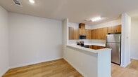 Located at 3786 Horizons Ave in Merced, CA, this thoughtfully designed one-bedroom, one-bathroom residence offers a clean, modern aesthetic with consistent light wood flooring flowing throughout every room. The open-concept layout connects the kitchen and living room seamlessly, creating an efficient and welcoming shared space. The kitchen is well-equipped with warm wood cabinetry, white quartz countertops, a stainless steel refrigerator, range, microwave, and a deep undermount sink — providing ample storage and functionality. The living area is bright and airy, featuring a ceiling fan, a large window that admits natural light, and a front entry door that opens to a spacious foyer. The bedroom is generously sized, highlighted by a ceiling fan, sliding glass doors that lead to an outdoor area, and a window with views of surrounding greenery. The bathroom includes a full soaking tub and shower combination. A dedicated laundry area with in-unit washer and dryer hookups adds everyday convenience. Neutral wall tones and clean lines throughout lend the space a fresh, move-in-ready feel well-suited for comfortable, modern living.