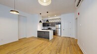Located at 2801 S Pennsylvania St in Indianapolis, this 2-bedroom, 1-bathroom unit offers a thoughtfully designed single-floor layout with modern finishes throughout. Warm hardwood-style flooring flows consistently across every room, creating a cohesive and inviting atmosphere.

The open-concept living and kitchen area serves as the heart of the unit. The kitchen is outfitted with dark wood cabinetry, stainless steel appliances including a refrigerator, stove, and microwave, and a bold geometric-patterned tile backsplash. A central island with a quartz-style countertop provides additional prep space and seating, while stylish pendant lights overhead complete the contemporary look.

The two bedrooms are bright and functional, with natural light brought in through multiple windows. The primary bedroom offers a comfortable footprint, and one bedroom features a set of double doors leading to a dedicated closet. The hallways connect the rooms efficiently throughout the layout.

The bathroom is finished with large hexagonal marble-look floor tiles and features a full soaking tub and shower combination with oil-rubbed bronze fixtures, lending an elegant contrast to the clean white walls.

A stackable in-unit washer and dryer adds everyday convenience, while a wall-mounted HVAC unit ensures year-round comfort. Clean white walls and modern light fixtures round out this well-appointed and move-in-ready space.