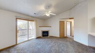 Located at 916 Harlocke St in Iowa City, Iowa, this single-floor unit offers a well-organized and comfortable layout designed for everyday living. The spacious living room serves as the heart of the home, anchored by a tile-surround fireplace with a wood mantel and complemented by a ceiling fan overhead. A textured ceiling adds character to the space, while large sliding glass doors flood the room with natural light and provide direct access to a private outdoor balcony. The kitchen is thoughtfully designed with warm oak cabinetry offering generous storage, white appliances including a range, built-in microwave, refrigerator, and dishwasher, as well as a double basin sink and a breakfast bar peninsula that connects to the carpeted living area. Light tile flooring runs throughout the kitchen. The bedrooms are carpeted and neutrally finished, each offering a clean, versatile space ready for personalization. Closet storage is well-represented, with at least one room featuring a full double-door closet. The bathroom includes a full tub-shower combination with a clean white surround, tile flooring, and a towel bar. Throughout the unit, warm wood trim accents and neutral wall tones create a cohesive and inviting atmosphere.