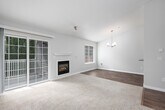 This single-floor residence offers a well-organized layout with a comfortable and cohesive design throughout. The living room is a standout space, featuring vaulted ceilings that enhance the sense of openness, a fireplace with a clean white surround, and a sliding glass door that invites natural light and provides access to an outdoor area with views of surrounding greenery. A secondary window further brightens the space, which is finished with plush wall-to-wall carpeting.

Adjacent to the living area, the dining space benefits from its own vaulted ceiling and an elegant chandelier, with warm hardwood-style flooring that continues into the kitchen. A pass-through window connects the dining area to the kitchen, which is efficiently designed with white shaker-style cabinetry, subway tile backsplash, stainless steel appliances including a range, refrigerator, and dishwasher, and a stainless steel sink.

The bedrooms are carpeted and neutral in tone, each featuring windows with blinds that allow for natural light and privacy. The bathroom is functional and clean, offering a single-sink vanity with a large mirror, wood-style flooring, and a shower-tub combination. Neutral wall tones and consistent finishes create a cohesive ambiance throughout the space.